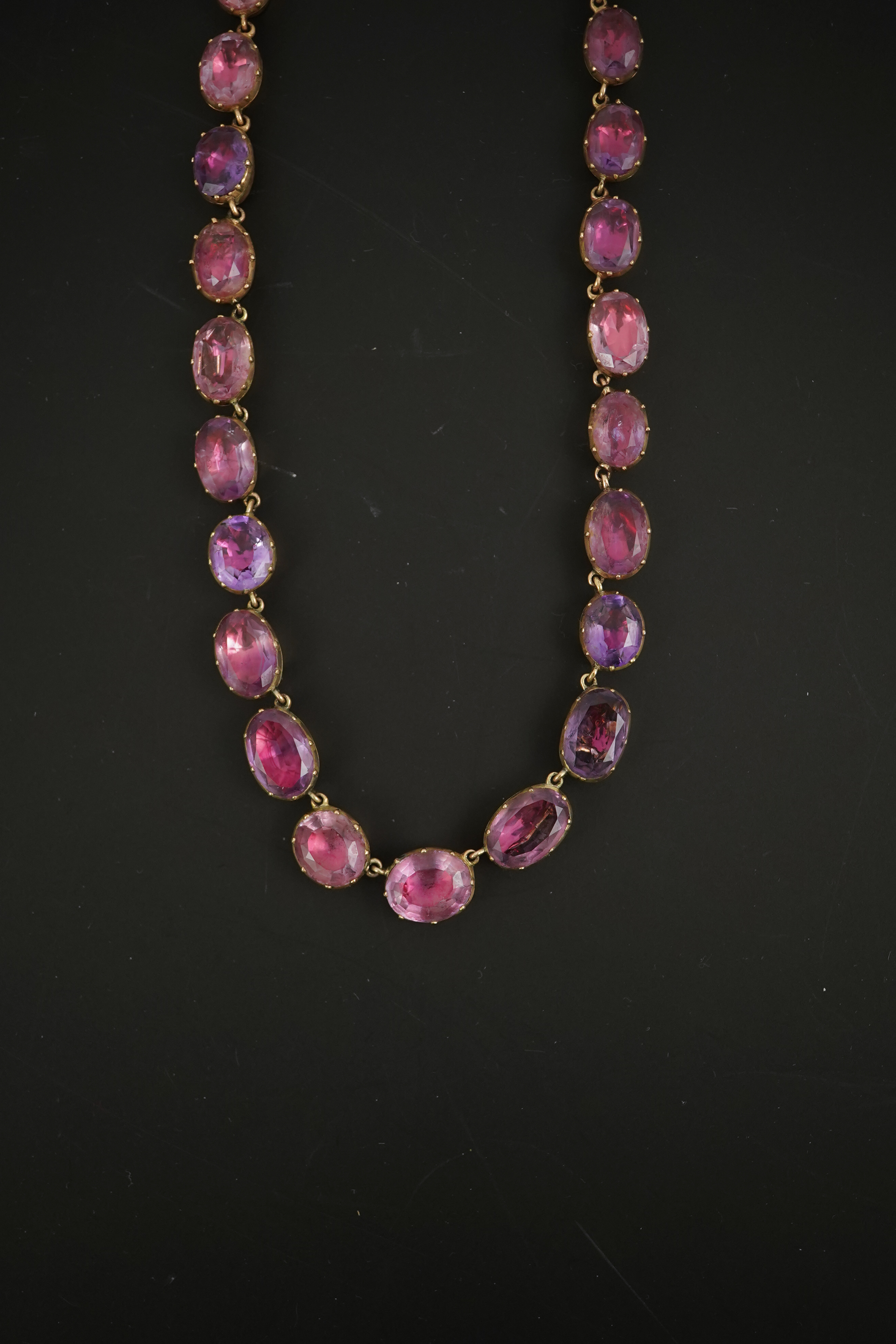 A 19th century gold and graduated oval cut foil backed amethyst or rock crystal set riviere necklace